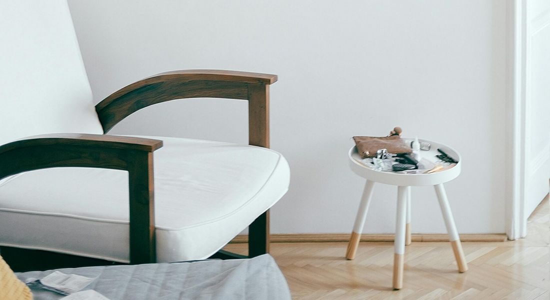 Woman folding a blanket over the back of a modern chair