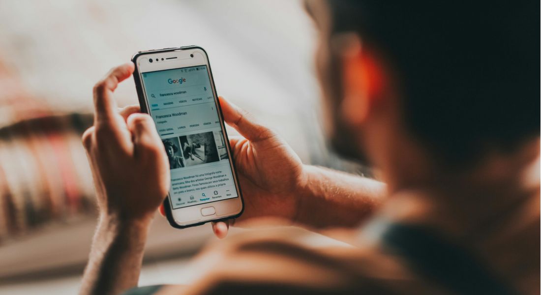 A man holding a smartphone with smart home screen